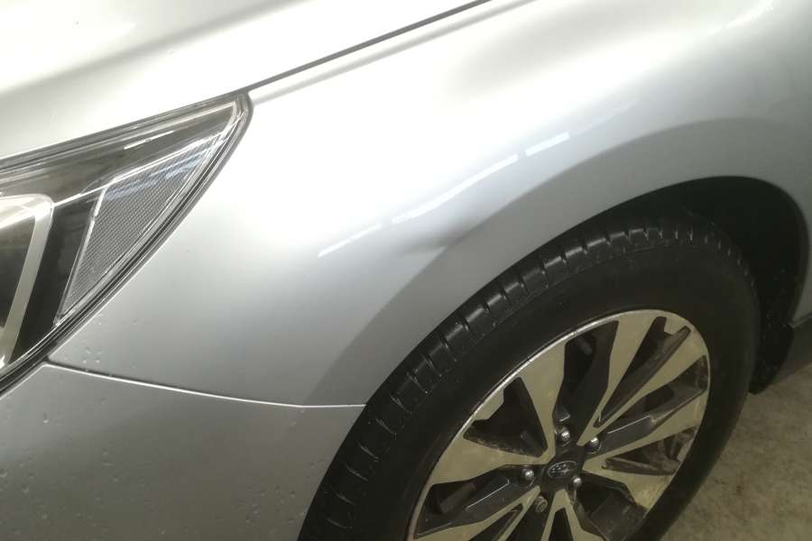 Wgniecenie parkingowe na przednim błotniku subaru outback